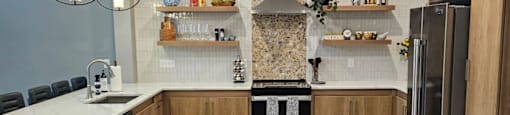 A modern kitchen with wooden floors and a central island.