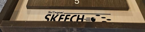 A shuffleboard table with the word SKEECH on it.