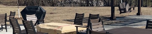 A patio with tables and chairs is empty.