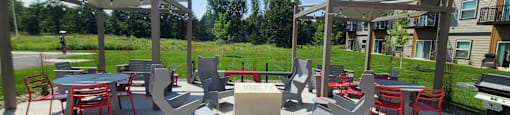 an outdoor patio area with tables and chairs and a grill