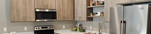 A modern kitchen with wooden cabinets and stainless steel appliances.
