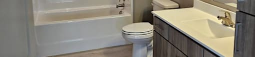 A bathroom with a toilet, sink, and bathtub.