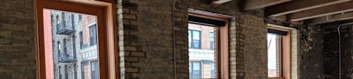 A room with wooden floors and brick walls.