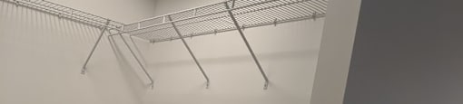 A white wall with a shelf and a light fixture.