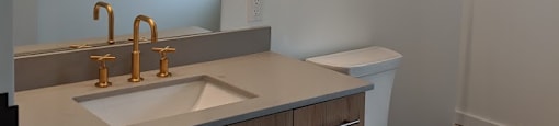 A white toilet sits next to a sink in a bathroom.