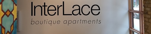 A wall with a logo that says InterLace boutique apartments.