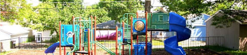 A playground with a blue slide and a green slide.