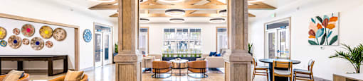 the lobby of a hotel with tables and chairs and a fireplace at The Parker Austin, Pflugerville, TX