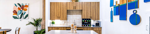 a kitchen with wooden cabinets and a marble counter top at The Parker Austin, Pflugerville, 78660
