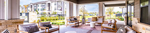 Covered patio with couches and chairs and a tv at The Parker Austin, Texas