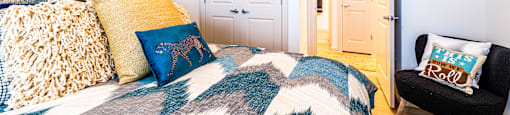 Bedroom with a bed and a chair and a door to a bathroom at The Parker Austin, Pflugerville, Texas