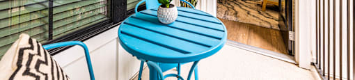 Small patio with a blue table and chairs at The Parker Austin, Pflugerville, 78660