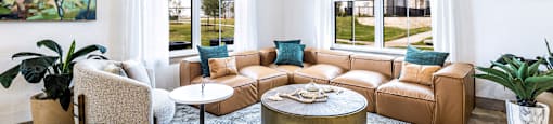 Living room with a leather couch and a round coffee table at The Parker Austin, Pflugerville, TX, 78660