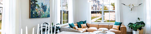 Living room and dining room with a wooden table and a large window at The Parker Austin, Pflugerville, TX