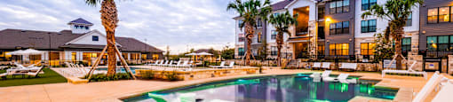 Swimming pool with two white chairs and a building in the background at The Parker Austin, Texas