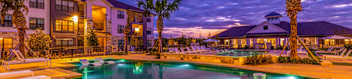 Swimming pool with palm trees at night at The Parker Austin, Pflugerville, Texas