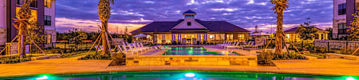 Swimming pool with palm trees and a building in the background at The Parker Austin, Pflugerville, Texas
