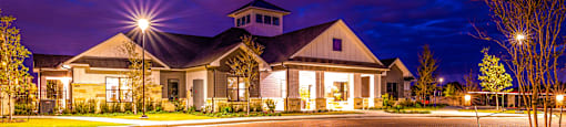House with a driveway and a street at night at The Parker Austin, Pflugerville, TX