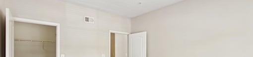 an empty bedroom with a closet and an open door