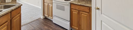 an empty kitchen with wooden cabinets and white appliances