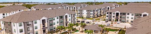 an aerial view of the resort style pool with lounge chairs and umbrellas at The Parker Austin, Pflugerville, Texas