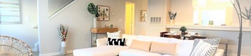 a living room with a white couch and a glass table