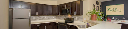 a large kitchen with stainless steel appliances and white counter tops