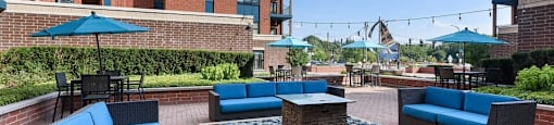 A patio with blue couches and a fire pit.