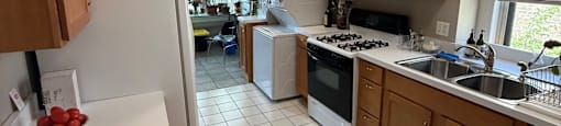 A kitchen with white appliances and brown cabinets.