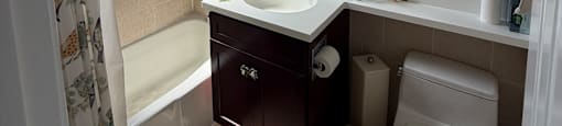 A small bathroom with a toilet, sink, and bathtub.