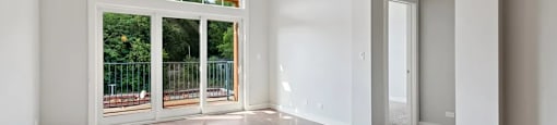 A room with a sliding glass door leading to a balcony.