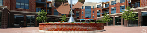 A large sculpture in the middle of a courtyard surrounded by buildings.