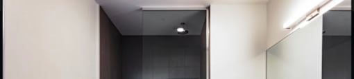 a black and white bathroom with a shower and sink