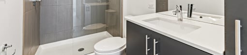 A modern bathroom with a white toilet and a walk-in shower.