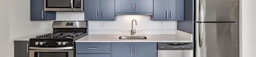 A kitchen with a stove, oven, sink, and refrigerator.