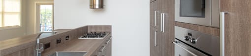 A modern kitchen with wooden cabinets and stainless steel appliances.