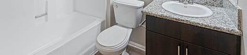 A white bathroom with a toilet, sink, and bathtub.