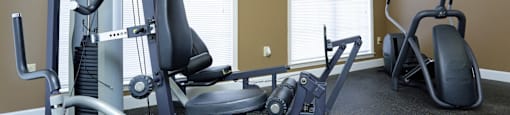 A gym with a weight machine and a bench.
