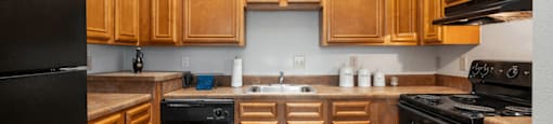 A kitchen with wooden cabinets and black appliances.