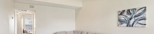 A living room with a grey sofa and a grey and white patterned ottoman.