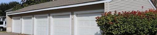 A two-car garage with a white door is situated in front of a house.