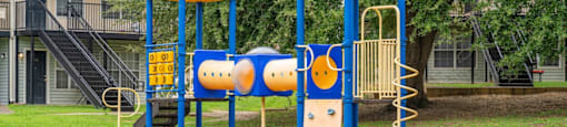 A playground with a blue and yellow structure and a slide.