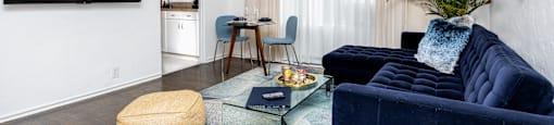 a living room with a blue couch and a glass coffee table