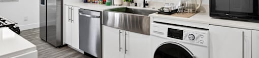 A modern kitchen with white cabinets and stainless steel appliances.