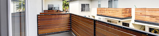 A balcony with a wooden railing and a glass door.