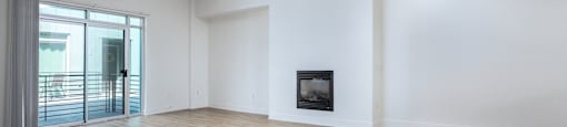 an empty living room with white walls and a fireplace