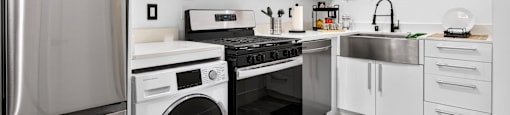 A modern kitchen with stainless steel appliances and white cabinets.
