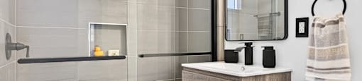 A modern bathroom with a walk-in shower and a large mirror above the vanity.