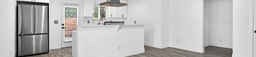 A modern kitchen with a refrigerator, sink, and stove.