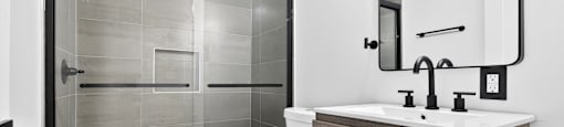 A modern bathroom with a walk-in shower and a white toilet.
